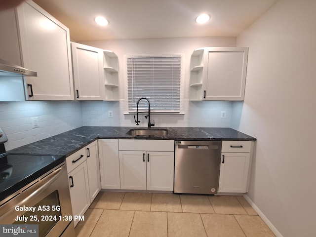 kitchen featuring light tile patterned flooring, sink, white cabinets, backsplash, and stainless steel appliances