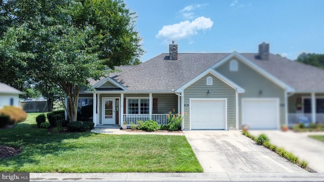 view of front of house featuring a front lawn, covered porch, and a garage