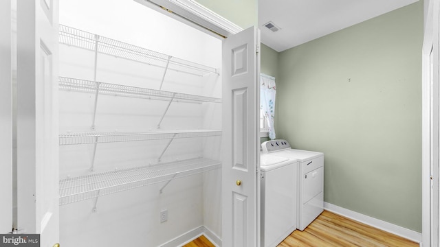 laundry room with light wood-type flooring and washing machine and dryer