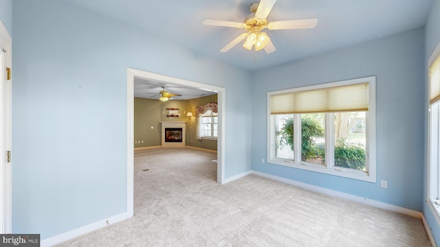 carpeted spare room featuring ceiling fan