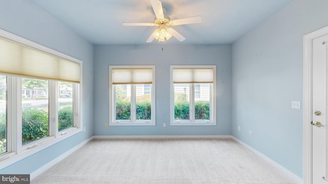 unfurnished room featuring plenty of natural light, ceiling fan, and light carpet