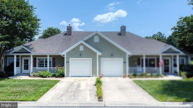 view of front of house with a garage, covered porch, and a front yard