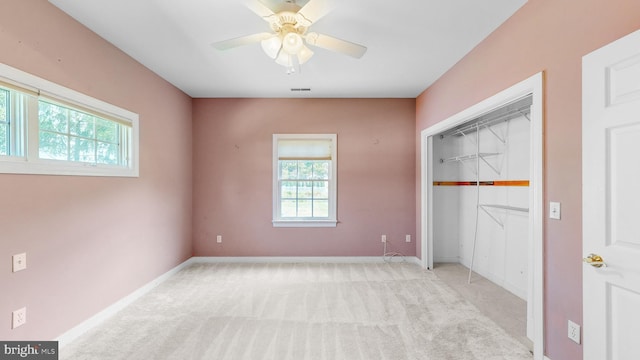 unfurnished bedroom featuring ceiling fan, light carpet, and a closet