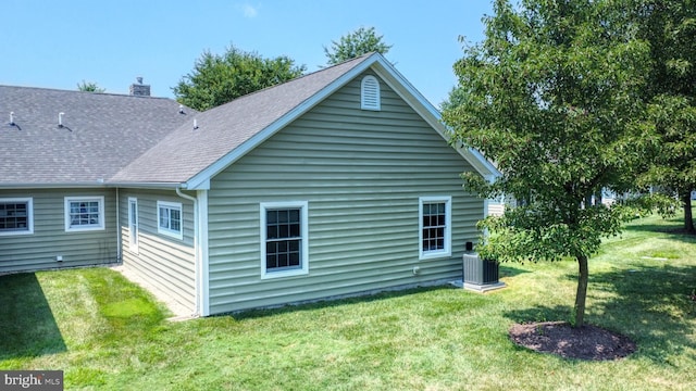 rear view of property with a yard and central AC unit