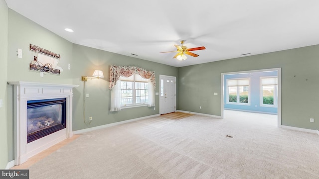 unfurnished living room with ceiling fan and light carpet