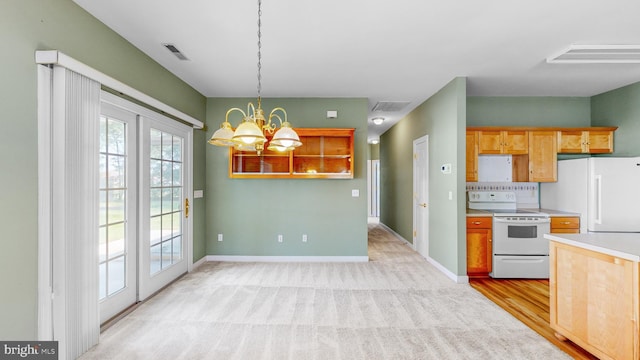 kitchen featuring pendant lighting, white appliances, french doors, an inviting chandelier, and light colored carpet