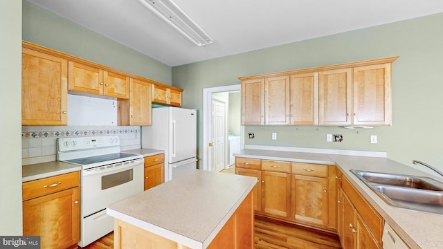 kitchen with white appliances, sink, light wood-type flooring, tasteful backsplash, and a kitchen island