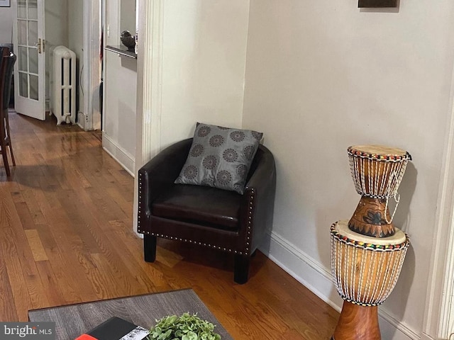 living area featuring hardwood / wood-style flooring and radiator heating unit