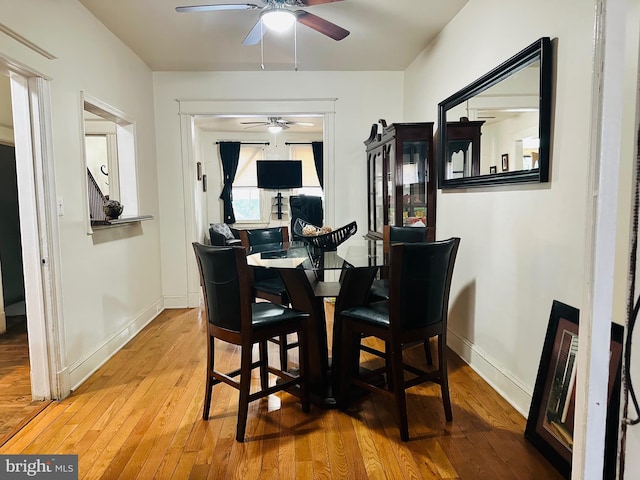 dining space with light wood-type flooring and ceiling fan