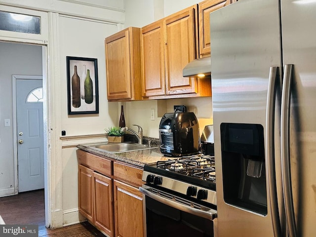 kitchen featuring dark wood-type flooring, wall chimney exhaust hood, sink, and stainless steel appliances