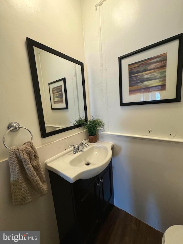 bathroom featuring wood-type flooring, toilet, and vanity