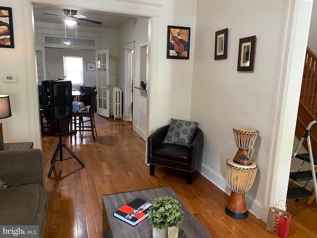 living room with hardwood / wood-style floors, ceiling fan, and radiator