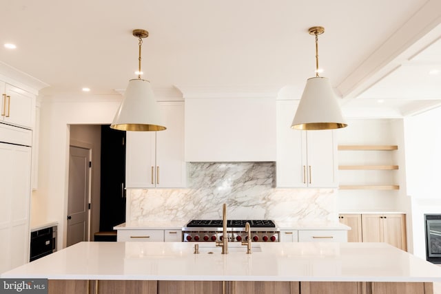 kitchen with backsplash, a large island with sink, and white cabinetry