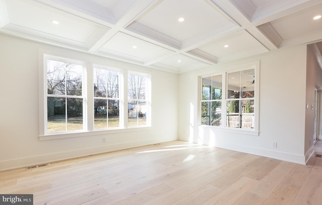 empty room with beam ceiling, light hardwood / wood-style floors, and coffered ceiling