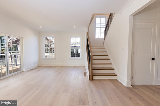 interior space with wood-type flooring, a wealth of natural light, and crown molding