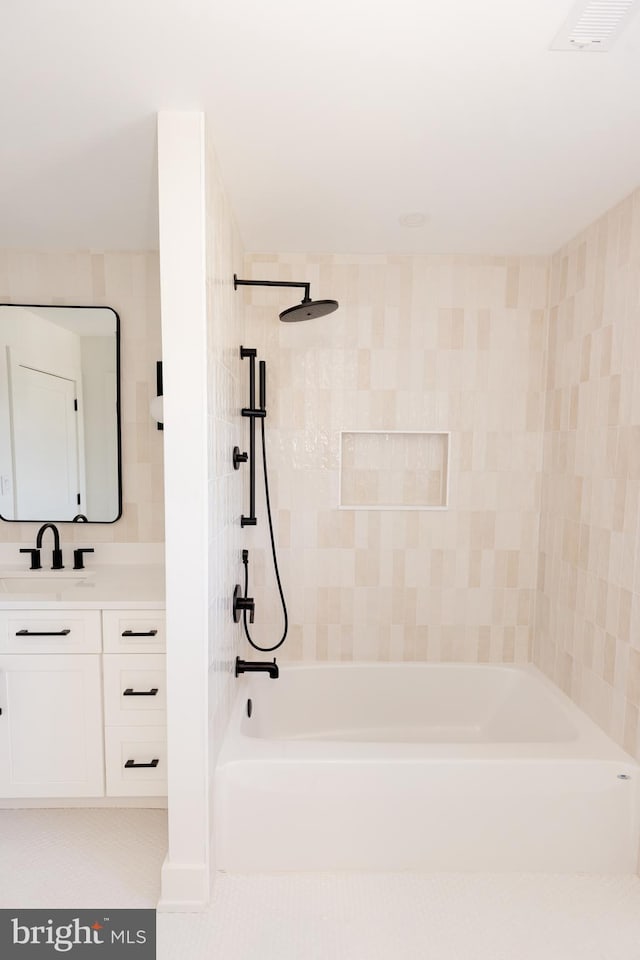 bathroom featuring vanity and tiled shower / bath combo