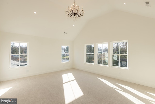 spare room featuring light colored carpet, high vaulted ceiling, and a notable chandelier