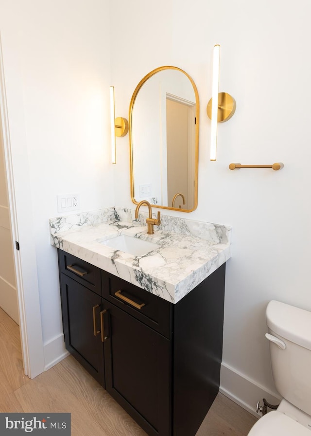 bathroom featuring hardwood / wood-style floors, vanity, and toilet