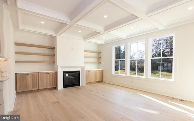 unfurnished living room with beam ceiling, light hardwood / wood-style floors, and coffered ceiling