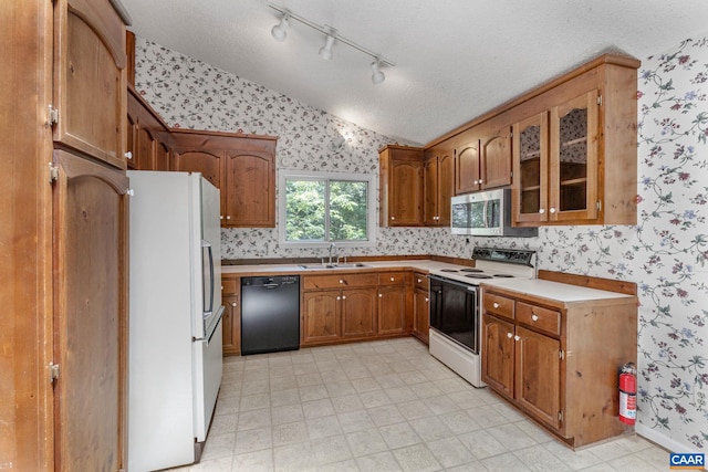 kitchen featuring a textured ceiling, lofted ceiling, sink, and white appliances