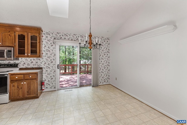 kitchen with lofted ceiling, white range oven, hanging light fixtures, and a notable chandelier