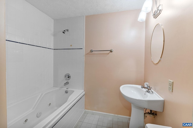 bathroom featuring toilet, a textured ceiling, and tiled shower / bath