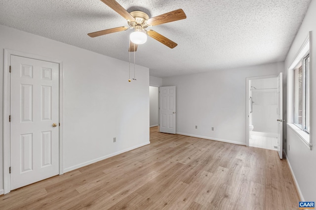 empty room with ceiling fan, light hardwood / wood-style flooring, and a textured ceiling