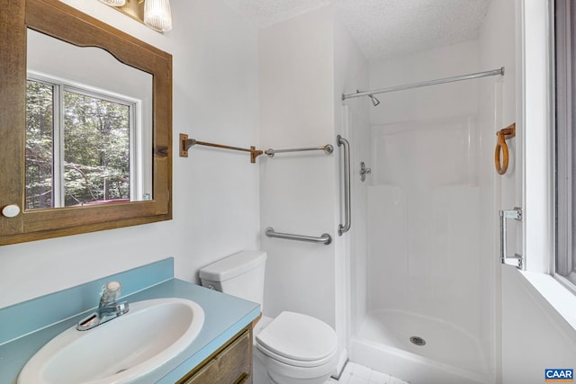 bathroom featuring a shower, vanity, a textured ceiling, and toilet