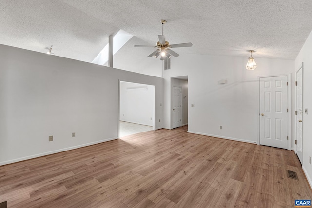 unfurnished living room with a textured ceiling, ceiling fan, vaulted ceiling, and light wood-type flooring