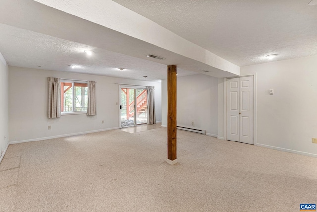 basement featuring baseboard heating, light carpet, and a textured ceiling