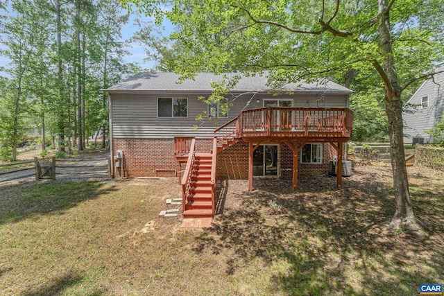 rear view of house featuring a lawn, central air condition unit, and a wooden deck