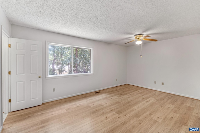 empty room with light wood-type flooring, a textured ceiling, and ceiling fan