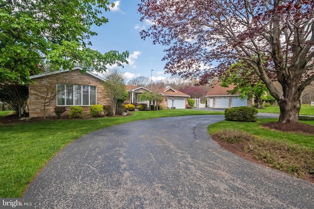 ranch-style home with a garage and a front lawn