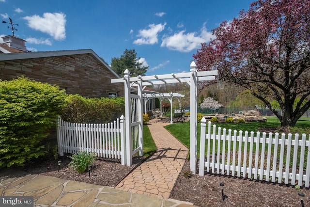 view of gate featuring a lawn and a pergola