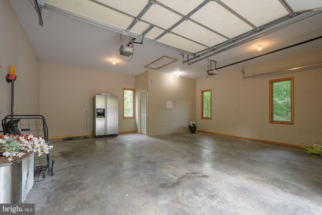 garage featuring stainless steel fridge and a garage door opener