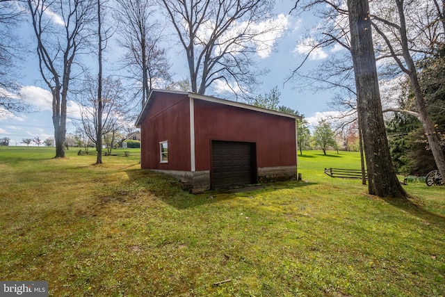 view of outbuilding featuring a garage and a yard