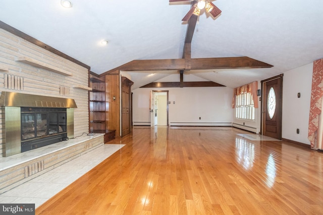 unfurnished living room with wooden walls, light hardwood / wood-style flooring, ceiling fan, and vaulted ceiling with beams