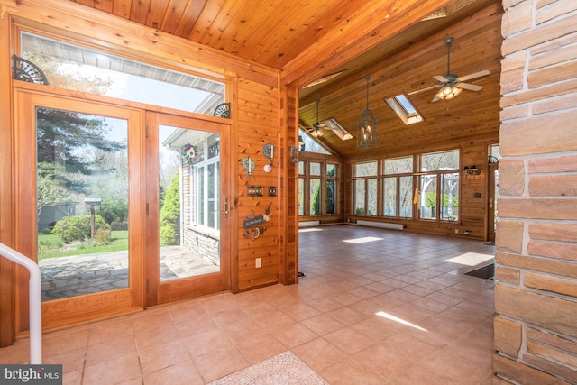 doorway with wooden ceiling, vaulted ceiling with skylight, light tile patterned floors, and ceiling fan