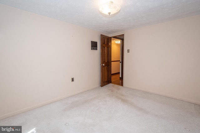 unfurnished room with a textured ceiling and light colored carpet