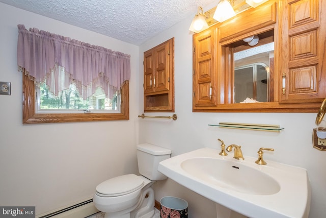 bathroom with sink, a textured ceiling, baseboard heating, and toilet