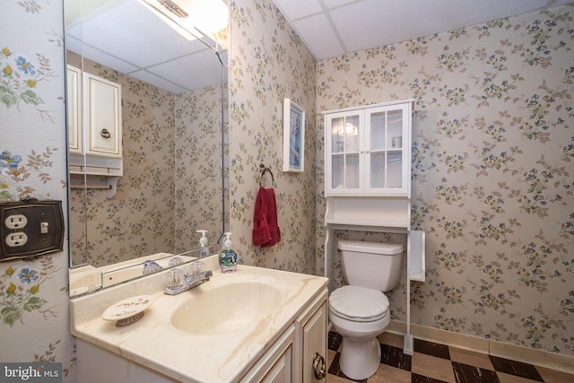 bathroom featuring tile patterned floors, toilet, vanity, and a paneled ceiling