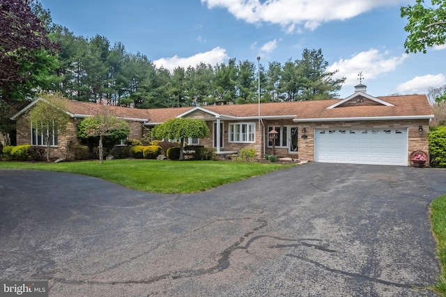 ranch-style home featuring a garage and a front lawn