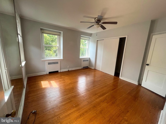 unfurnished bedroom featuring light hardwood / wood-style floors, radiator, and ceiling fan