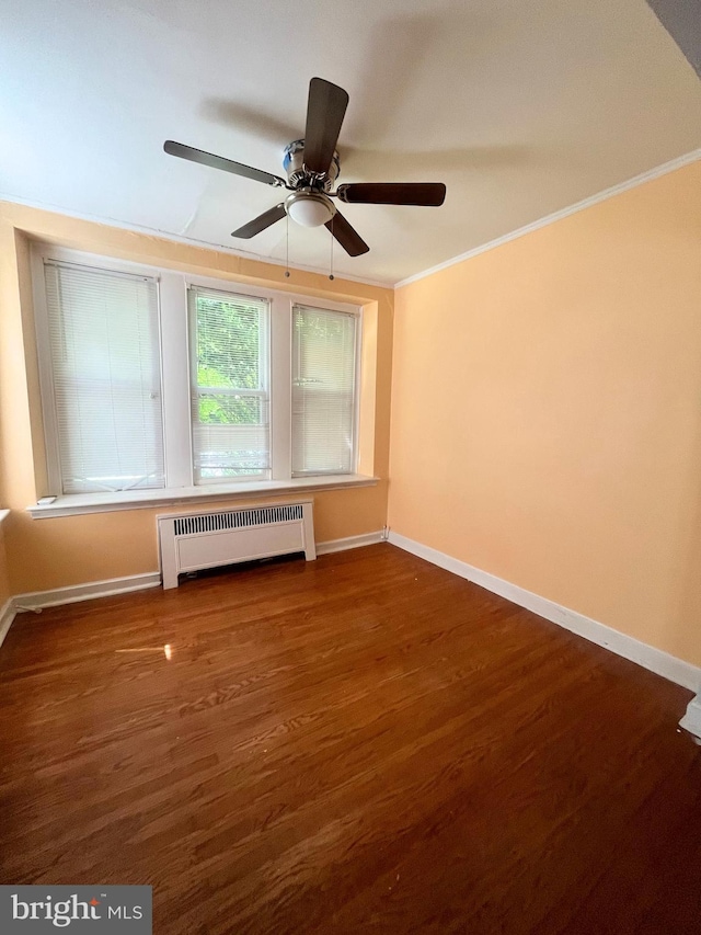 empty room featuring ceiling fan, radiator heating unit, crown molding, and dark hardwood / wood-style floors