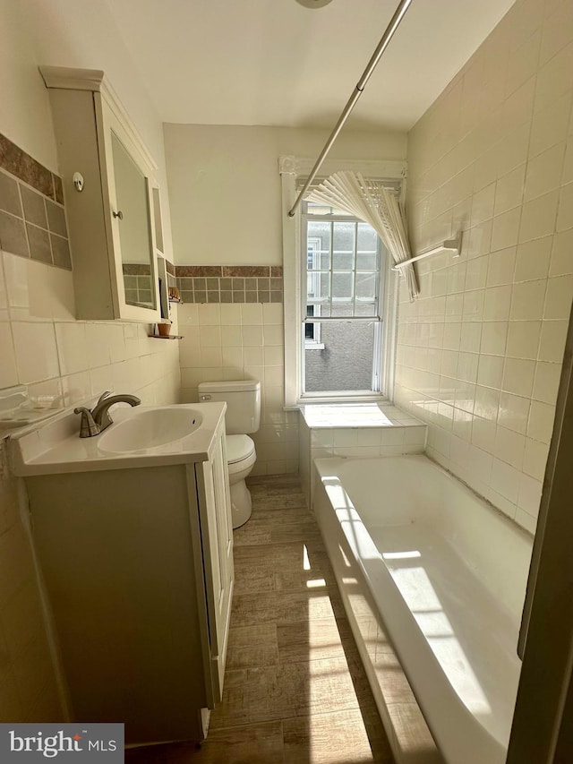 full bathroom featuring vanity, hardwood / wood-style flooring, tile walls, toilet, and shower with separate bathtub