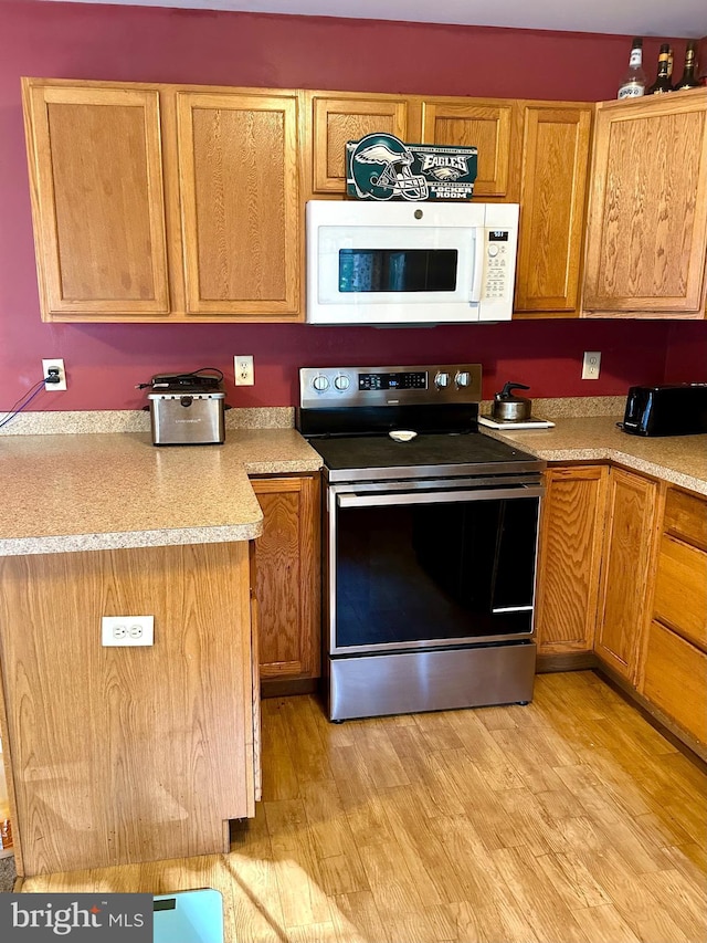 kitchen with light hardwood / wood-style flooring and stainless steel electric range