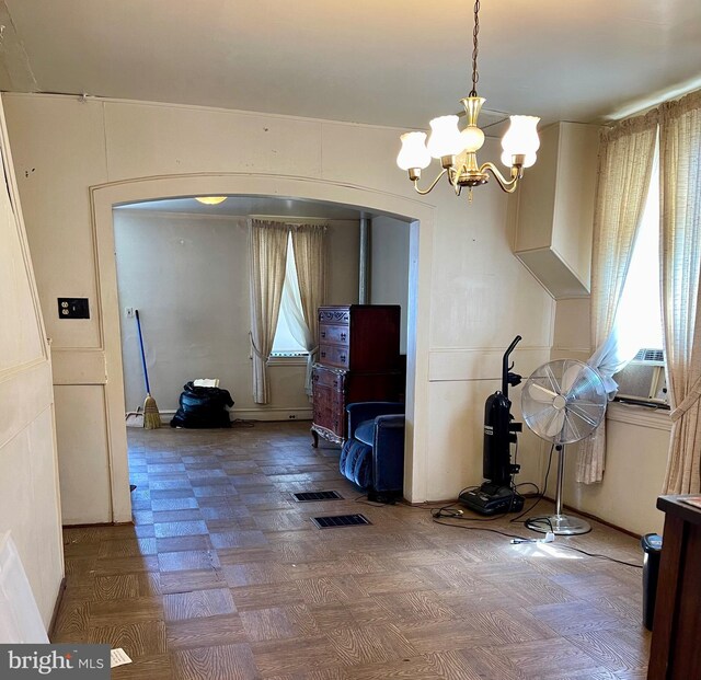 dining area featuring cooling unit, parquet floors, and a chandelier