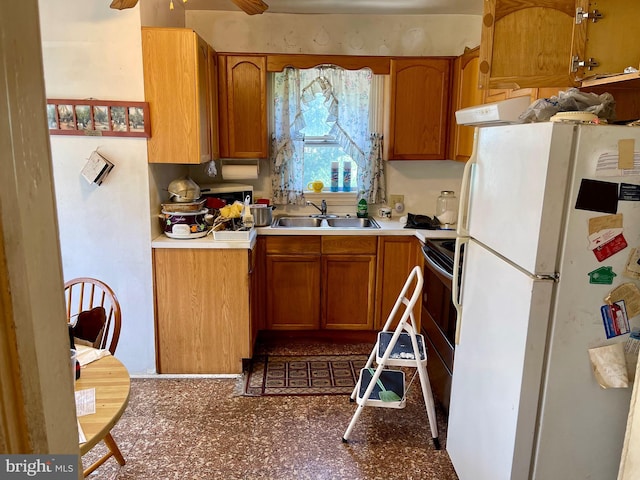 kitchen featuring ceiling fan, sink, and white refrigerator