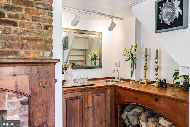 bar featuring sink, track lighting, and wood counters