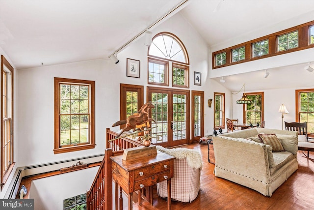 living room with french doors, lofted ceiling, wood-type flooring, and a baseboard heating unit